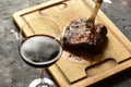 Roasted beef ribs with a glass of red wine presented on the table, traditional Argentine cuisine, Asado barbecue,