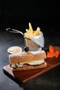 Roasted Beef Sub Sandwich with french fries bucket served on wooden board isolated on dark background side view of breakfast food Royalty Free Stock Photo