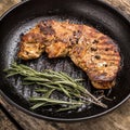 Roasted beefsteak with bunch of rosemary on grill pan