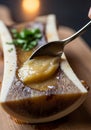 Roasted bone marrow canoe with spoon garnished with herbs Royalty Free Stock Photo