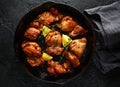 Roasted boneless skinless chicken thighs in lemon and thyme dressing served in vintage cast iron skillet, frying pan