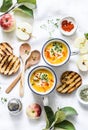 Roasted butternut squash and apples vegetarian soup on light background, top view.