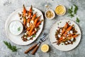 Roasted carrots lentil salad with feta, herb yogurt and dukkah on a light concrete background. Vegetarian food.