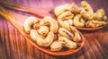 Roasted cashew nuts on a wooden spoon.Roasted salted cashew nuts on white background. Healthy food, cashews rich in heart friendly