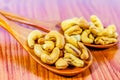 Roasted cashew nuts on a wooden spoon.Roasted salted cashew nuts on white background. Healthy food, cashews rich in heart friendly