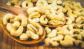 Roasted cashew nuts on a wooden spoon.Roasted salted cashew nuts on white background. Healthy food, cashews rich in heart friendly