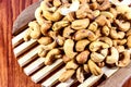 Roasted cashew nuts on a wooden spoon.Roasted salted cashew nuts on white background. Healthy food, cashews rich in heart friendly