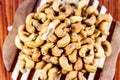 Roasted cashew nuts on a wooden spoon.Roasted salted cashew nuts on white background