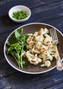 Roasted cauliflower and fresh green salad on a brown plate Royalty Free Stock Photo