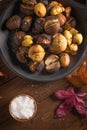 Roasted chestnuts in cast iron pan on an old board Royalty Free Stock Photo