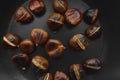 Roasted chestnuts in a cast iron skillet on a wooden table Royalty Free Stock Photo