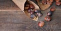 Roasted chestnuts  in a papaer bag son wooden table Royalty Free Stock Photo
