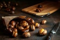 Roasted chestnuts in paper bag on black grunge background. Dark low key photo. Traditional food concept. Selective focus, blurred