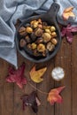 Roasted chestnuts with salt in cast iron grilling pan over rustic wooden board. Top view. Flat lay Royalty Free Stock Photo