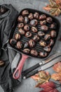Roasted chestnuts served in chestnut pan on an old table. Royalty Free Stock Photo