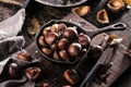 Roasted chestnuts served in a special perforated chestnut pan on an old wooden table. Royalty Free Stock Photo