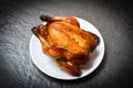 Roasted chicken - baked whole chicken grilled on white plate and dark background on top view Royalty Free Stock Photo