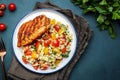 Roasted chicken breast with tabbouleh salad with bulgur, tomatoes and parsley with oil lemon dressing, green table background, top