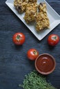 Roasted chicken drumsticks on a plate. Breaded chicken drumsticks, fried chicken. Dark wooden background