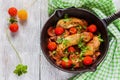 Roasted chicken fillet, cooked with mushrooms, garlic, paprika and olive oil. Cast-iron skillet and fresh cherry tomatoes on Royalty Free Stock Photo