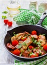 Roasted chicken fillet, cooked with mushrooms, garlic, paprika and olive oil. Cast-iron skillet and fresh cherry tomatoes Royalty Free Stock Photo