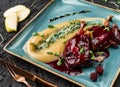 Roasted Chicken or fried quail with berries and apple sauce and micro greens on plate over black background. Hot Meat Dishes, top Royalty Free Stock Photo