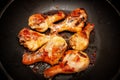 Roasted chicken legs in a black pan