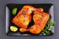 Roasted chicken legs on black plate Royalty Free Stock Photo