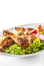 Roasted chicken legs with lettuce salad potatoes and tomatoes isolated on white