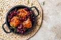 Roasted chicken legs with red grapes on pan over light beige background. Royalty Free Stock Photo