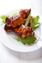 Roasted chicken legs with rocket leaves on a plate Royalty Free Stock Photo