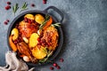 Roasted chicken legs with root vegetables, lemon, garlic, cranberry and rosemary on pan Royalty Free Stock Photo