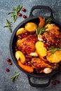 Roasted chicken legs with root vegetables, lemon, garlic, cranberry and rosemary on pan Royalty Free Stock Photo