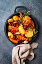 Roasted chicken legs with root vegetables, lemon, garlic, cranberry and rosemary on pan Royalty Free Stock Photo