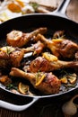 Roasted chicken legs with rosemary, garlic and lemon in a cast iron skillet Royalty Free Stock Photo