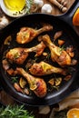 Roasted chicken legs with rosemary, garlic and lemon in a cast iron skillet