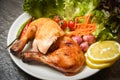 Roasted chicken legs white plate with lemon chilli spicy herbs spices and salad lettuce vegetable