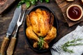 Roasted chicken with rosemary served on black plate with sauces on wooden table, top view. Royalty Free Stock Photo