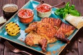 Roasted Chicken or turkey with spices, lemon, tomato sauce, basil and pita bread on plate on dark wooden background. Thanksgiving Royalty Free Stock Photo