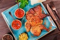 Roasted Chicken or turkey with spices, lemon, tomato sauce, basil and pita bread on plate on dark wooden background. Thanksgiving Royalty Free Stock Photo