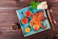 Roasted Chicken or turkey with spices, lemon, tomato sauce, basil and pita bread on plate on dark wooden background. Thanksgiving Royalty Free Stock Photo