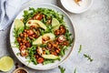 Roasted chickpea salad with avocado and tomatoes in white bowl, top view. Healthy vegan food concept