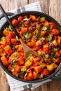 Roasted chili sweet potatoes and black beans with tomatoes, celery close-up in a pan. Vertical top view