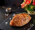 Roasted Christmas ham of turkey on dark rustic background. Royalty Free Stock Photo