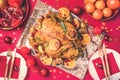 Roasted Christmas turkey with orange slices, cranberries, garlic with festive decoration, candles, tangerine, pomegranate, golden Royalty Free Stock Photo