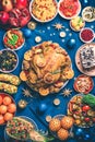 Roasted Christmas turkey with orange slices, cranberries, garlic, festive decoration, candles, tangerine, pomegranate, golden Royalty Free Stock Photo