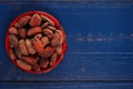 Roasted cocoa chocolate beans on dark blue wood background