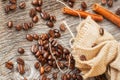 Roasted coffee beans, burlap sac, rustic wooden table, cinnamon. Vintage background, grunge texture. Top view. Royalty Free Stock Photo