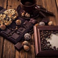 Roasted coffee beans, chocolate, candy, nuts, cup and the frame for inscriptions on the wooden background Royalty Free Stock Photo