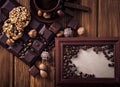 Roasted coffee beans, chocolate, candy, nuts, cup and the frame for inscriptions on the wooden background Royalty Free Stock Photo